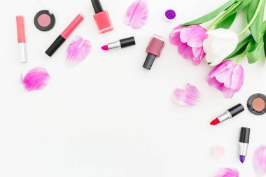 Çerçeve çiçek ve kozmetik, ruj, beyaz arka plan üzerinde oje yapılmış. Üst te. Düz yatıyordu