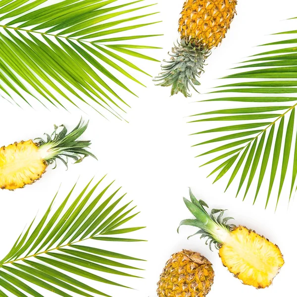 Tropical frame made of pineapple and mango fruit with palm leaves on white background. Flat lay, top view.