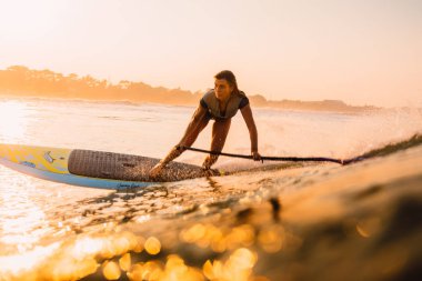 12 Nisan 2019. Bali, Endonezya. Okyanus dalgası üzerinde Paddle sörfçü binmek Stand Up. Bali dalgalar sörf Paddle Stand Up