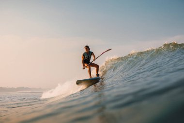12 Nisan 2019. Bali, Endonezya. Okyanus dalgası üzerinde Paddle sörfçü binmek Stand Up. Bali dalgalar sörf Paddle Stand Up