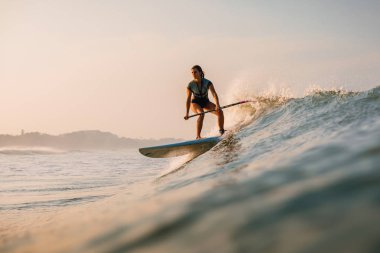 12 Nisan 2019. Bali, Endonezya. Okyanus dalgası üzerinde Paddle sörfçü binmek Stand Up. Bali dalgalar sörf Paddle Stand Up