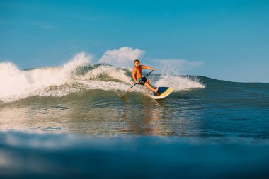 12 Nisan 2019. Bali, Endonezya. Okyanus dalgası üzerinde Paddle sörfçü binmek Stand Up. Bali dalgalar sörf Paddle Stand Up