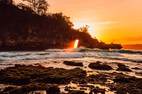 ビーチで波と明るい夕日を持つ海の岩 ヌサペニダ — ストック写真