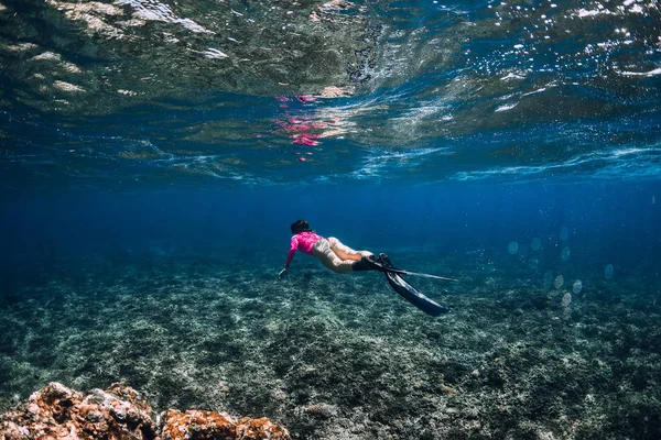 女性のフリーダイバーはサンゴ礁の上にフィンで滑ります 青い海でのフリーダイビング — ストック写真