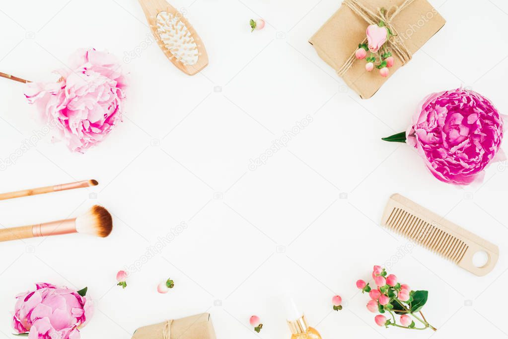 Beauty frame composition of pink peony with hairbrush, tassel and gift box on white background. Flat lay, top view