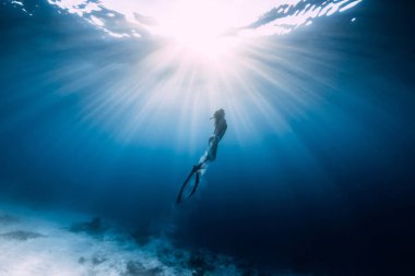 Kadın serbest dalgıç yüzgeçli kumlu deniz üzerinde kayar