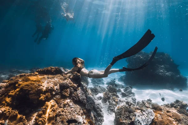 妇女自由潜水者滑翔与鳍和珊瑚 在蓝色的海洋中自由潜水 — 图库照片