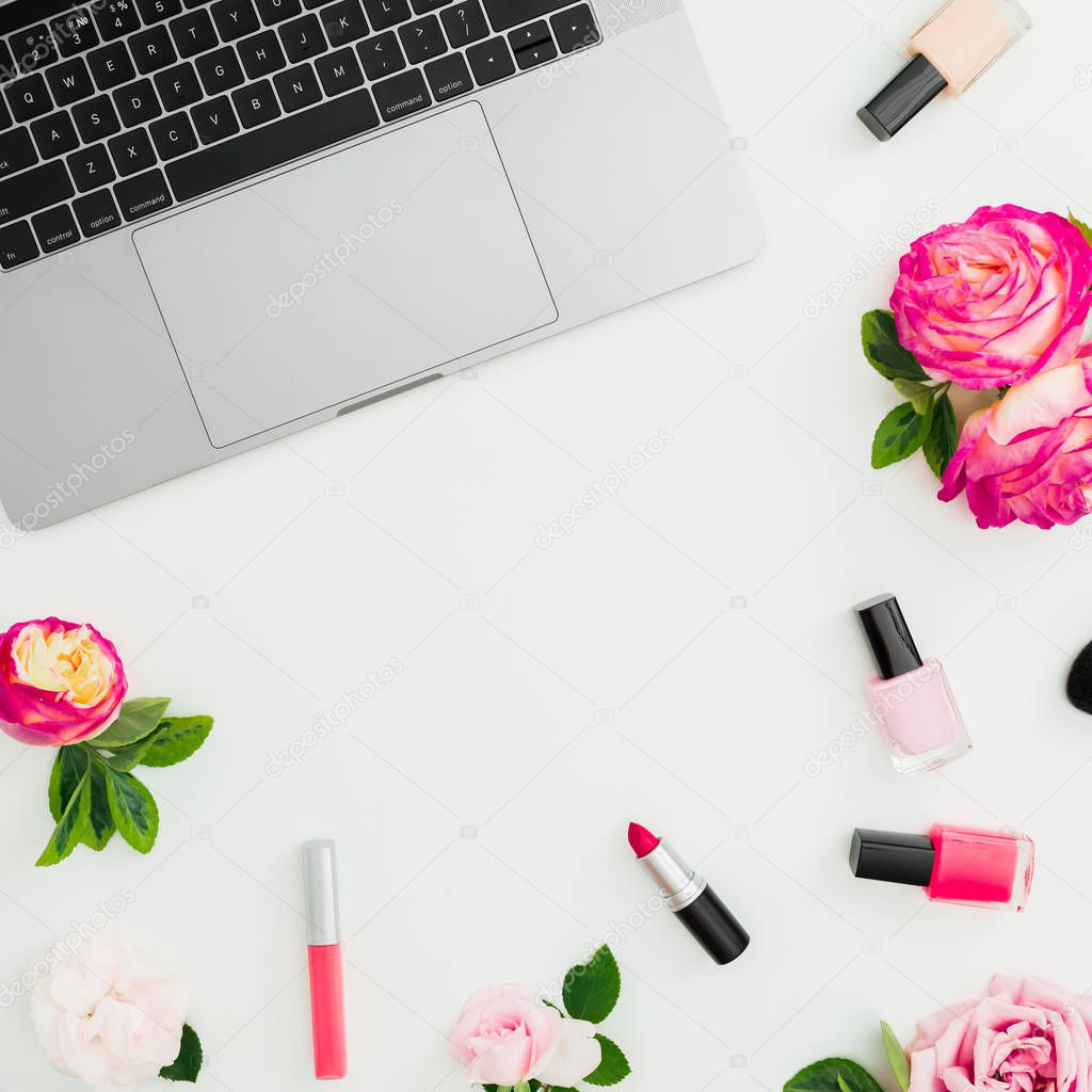 Laptop, roses flowers and feminine cosmetics isolated on white background. Flat lay. Top view. Frame composition with copy space