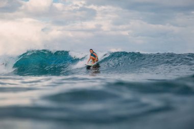 Sörf tahtasındaki sörf kızı. Sörf sırasında okyanusta bir kadın. Sörfçü ve dalga