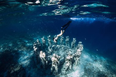 12 Mayıs 2019. Gili Meno, Endonezya. Sualtı heykelleri ile kadın ücretsiz dalgıç. Okyanusta sualtı turizmi.