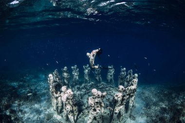 12 Mayıs 2019. Gili Meno, Endonezya. Sualtı heykelleri ile kadın ücretsiz dalgıç. Okyanusta sualtı turizmi.