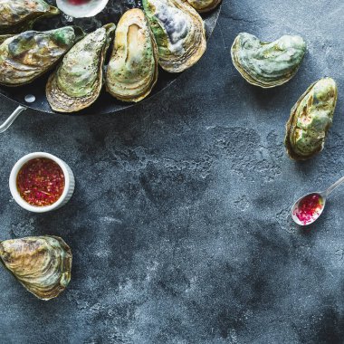 Karanlık masada istiridye deniz ürünleri. Düz yatıyordu. Üstte görüntü.