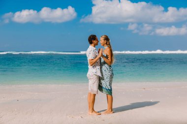 Mavi okyanus ile tropikal plajda bebek bekliyor kocası ile güzel hamile kadın