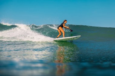 12 Nisan 2019. Bali, Endonezya. Okyanus dalga üzerinde Paddle sörf kız binmek Stand Up. Bali'de Paddle sörf stand up