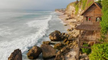 Okyanus dalgaları ile kıyı şeridihavadan görünümü. Bali Plaj, eski ev ve dalgalar