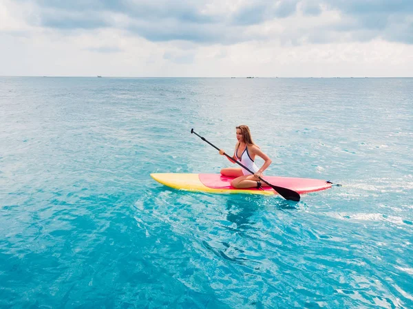 Aerial view of woman on stand up paddle board in blue ocean. — Stock Photo, Image