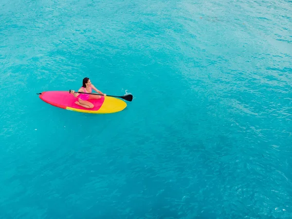 Vue aérienne de la femme debout planche à pagaie dans l'océan bleu . — Photo