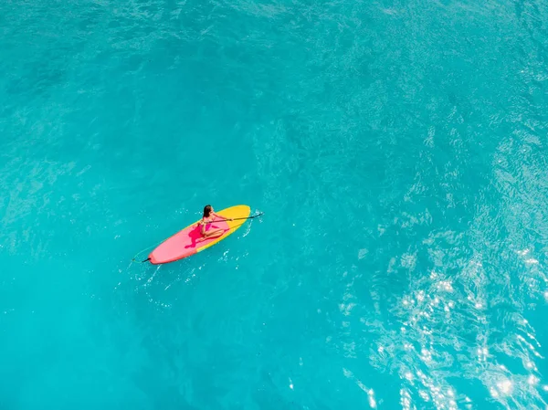 Vue aérienne de la femme debout planche à pagaie dans l'océan bleu . — Photo
