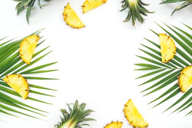 Dilimlenmiş ananas ve avuç içi beyaz arka planda yaprakları çerçevesi. F
