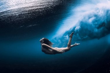 Kadın okyanus dalgası ile sualtı yüzmek.