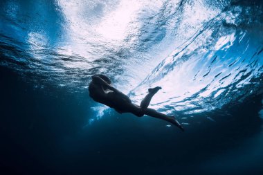 Genç kadın varil altında dalga ile sualtı dalış