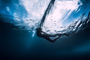 Genç kadın varil altında dalga ile sualtı dalış