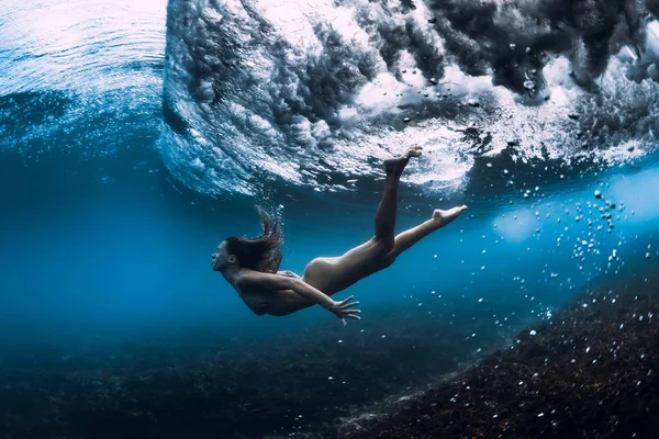 Vrouw zwemmen onderwater met Ocean Wave. — Stockfoto