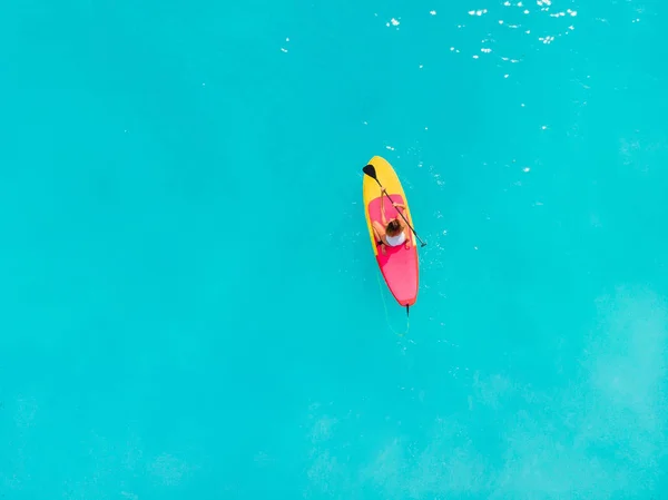 Femme relax sur stand up paddle board sur un océan bleu calme — Photo