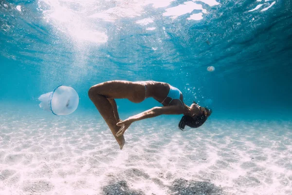 Mergulhador mulher desliza sobre o mar arenoso com água-viva. Mergulho livre em — Fotografia de Stock