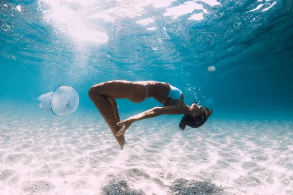 Woman Diver glider över sand havet med maneter. Fridykning i — Stockfoto