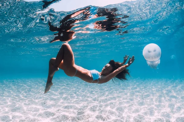 Donna subacquea scivola sul mare sabbioso con meduse. Apnea in — Foto Stock
