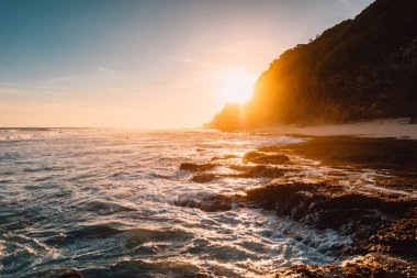 Bali gün batımında okyanus, dalgalar ve güneş ışığı ile Plaj