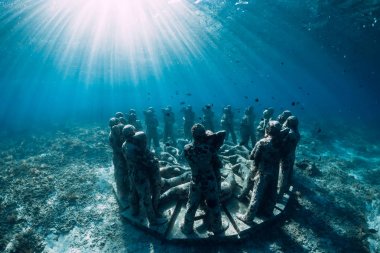 Mavi okyanusta balıklarla dolu sualtı heykelleri. Okyanusta sualtı turizmi.