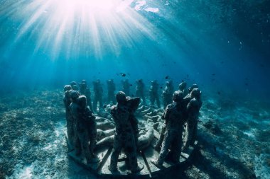 Mavi okyanusta balıklarla dolu sualtı heykelleri. Okyanusta sualtı turizmi.