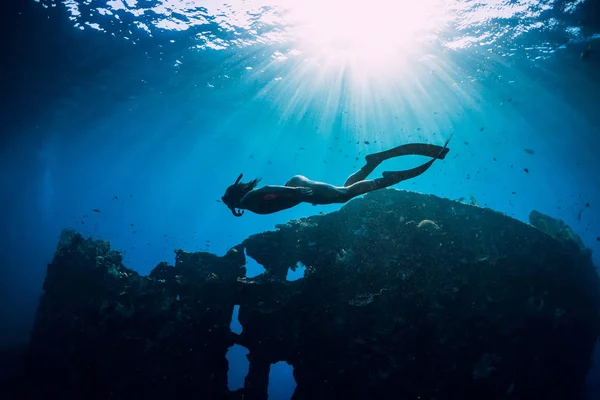 Woman freediver glides with fins at wreck ship. Freediving in bl — Stock Photo, Image