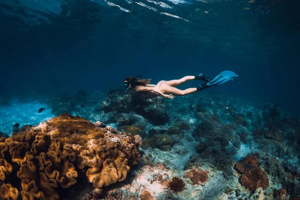 Yüzgeçli serbest dalgıç kadın su altında mercan alt üzerinde süzülür — Stok fotoğraf