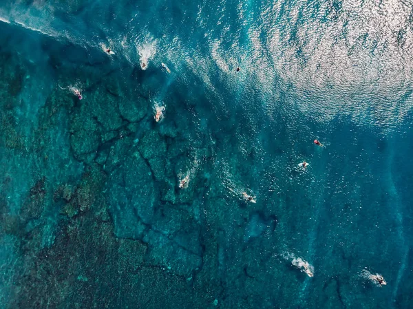 Sörfçülerin havadan görünümü ve mavi berrak okyanusta dalga. Üstte görüntü — Stok fotoğraf