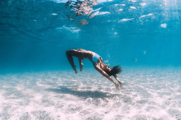 Женщина-дайвер скользит по песчаному морю с медузами. Фридайвинг — стоковое фото