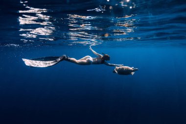 Yüzgeçli kadın freediver t deniz kaplumbağası ile sualtı süzülür