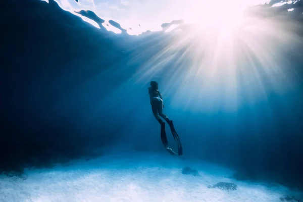 Freediver kobieta z płetwami pływać pod wodą w morzu. — Zdjęcie stockowe