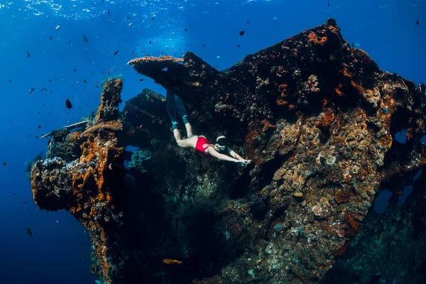 Woman free diver swim with fins at wreck ship. Freediving in oce