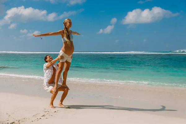 Junge schwangere Frau mit Ehemann entspannt sich am Paradiesstrand. ha — Stockfoto