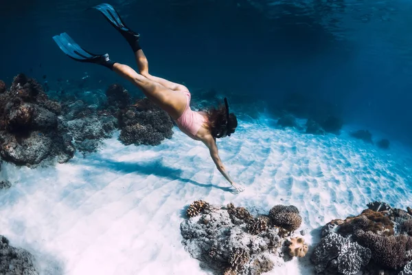 Kadın freediver mercanlar yakın kumlu alt üzerinde yüzgeçleri ile dalış. Fr — Stok fotoğraf