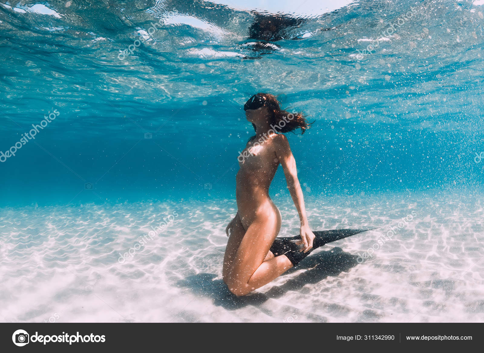 Femme plongeuse avec des nageoires posant sur la mer de sable. Plongée  libre unde image libre de droit par Keola © #311342990