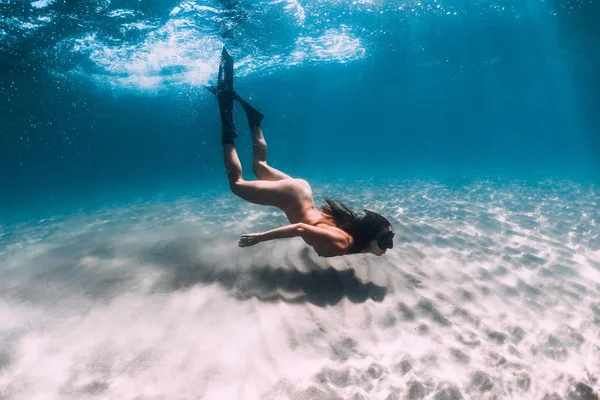 Naked woman freediver glides over sandy bottom. Beautiful woman — Stock Photo, Image