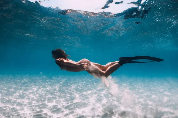 Freediver with fins glides over sandy sea in transparent ocean. — Stock Photo, Image