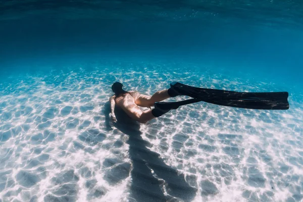 Mujer desnuda freediver se desliza sobre el fondo arenoso. Hermosa mujer —  Fotos de Stock