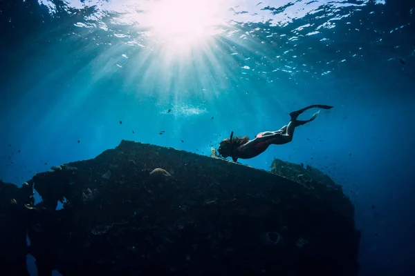 Freitauchermädchen in rosa Badebekleidung mit Flossen, die unter Wasser schwimmen — Stockfoto