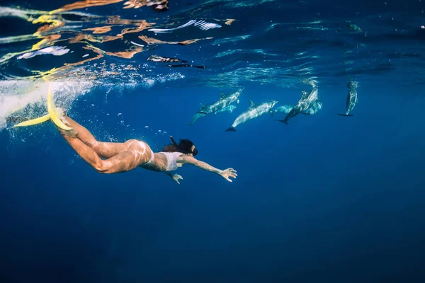 Une jeune femme nage sous l'eau avec des dauphins dans l'océan. Maurice — Photo