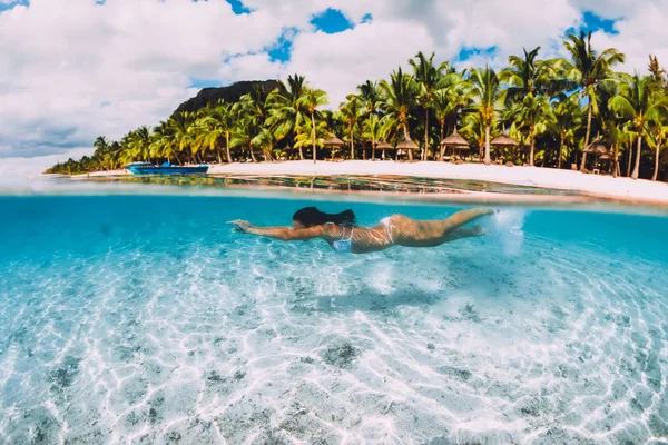 Jonge aantrekkelijke vrouw zwemmen onder water in transparant blauw o — Stockfoto